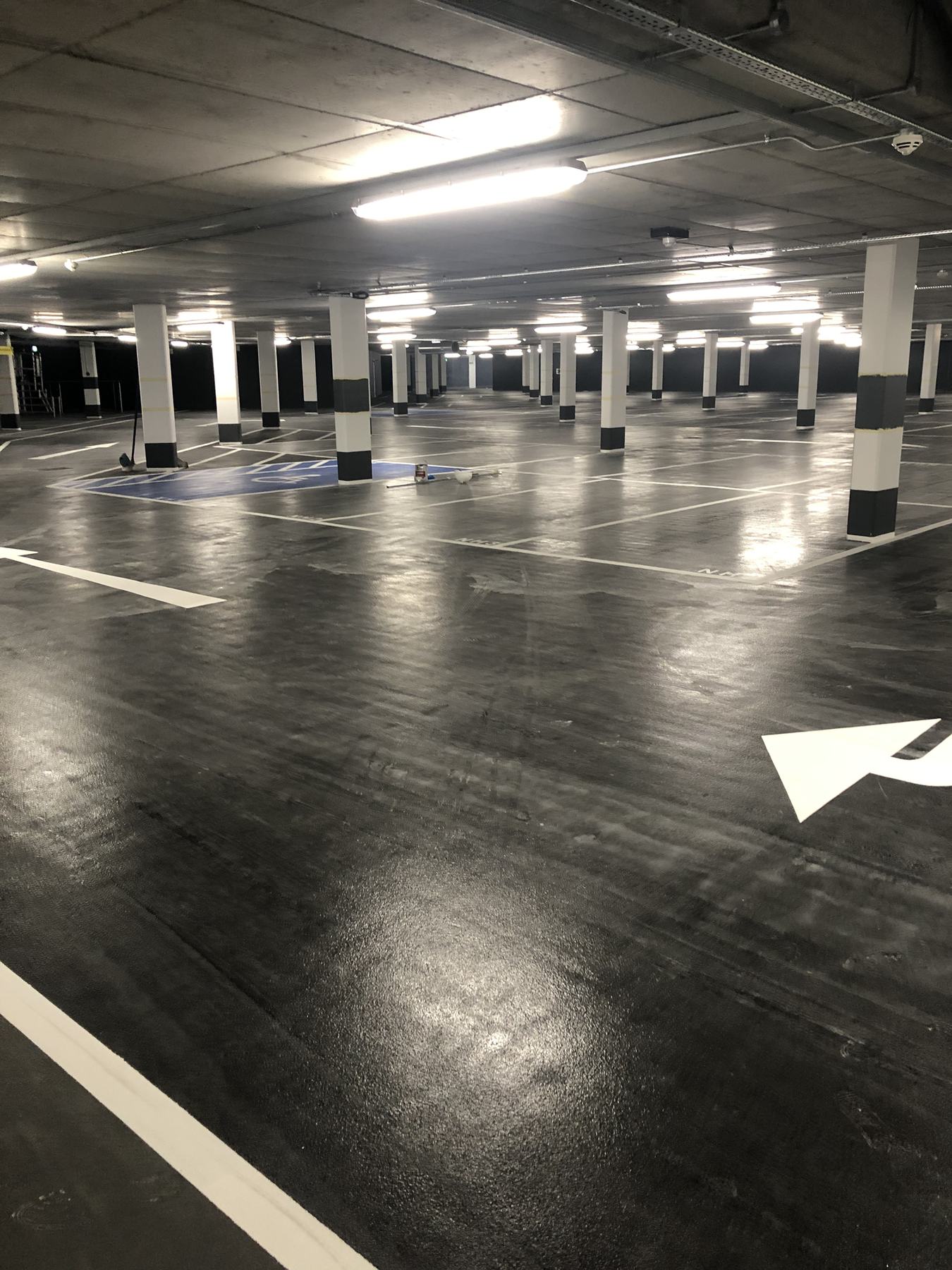 A freshly coated dark car park floor with white markings