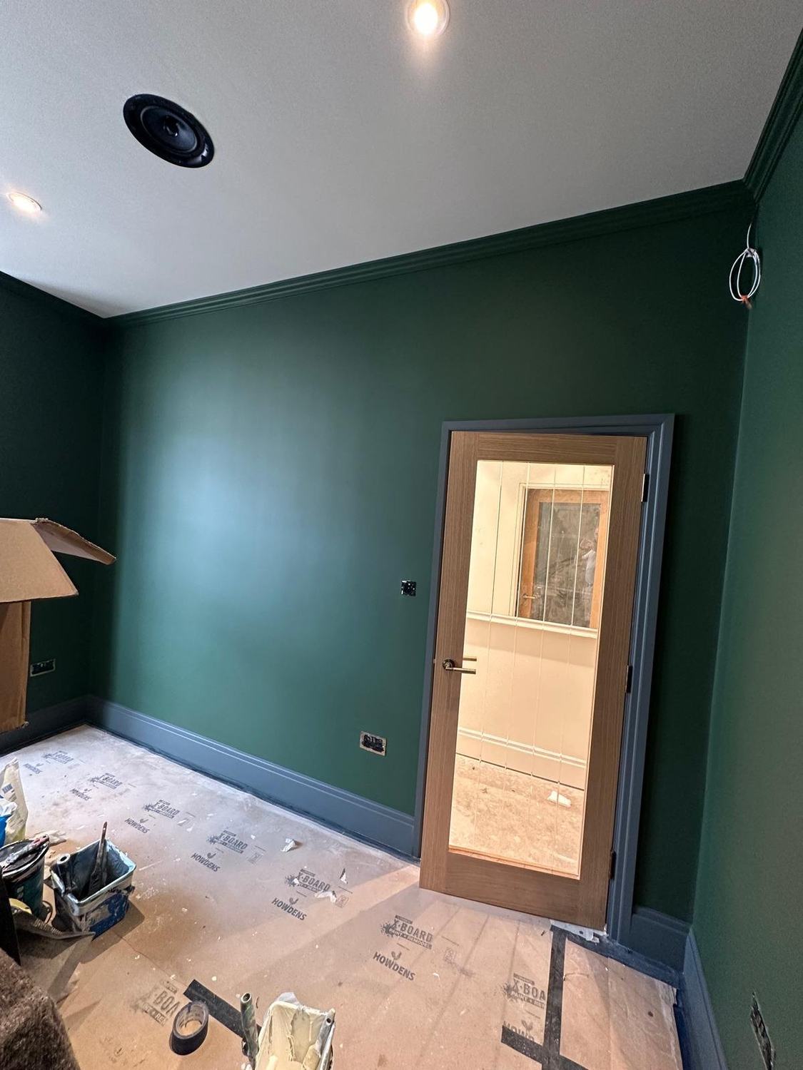 A room painted deep green with a glazed door