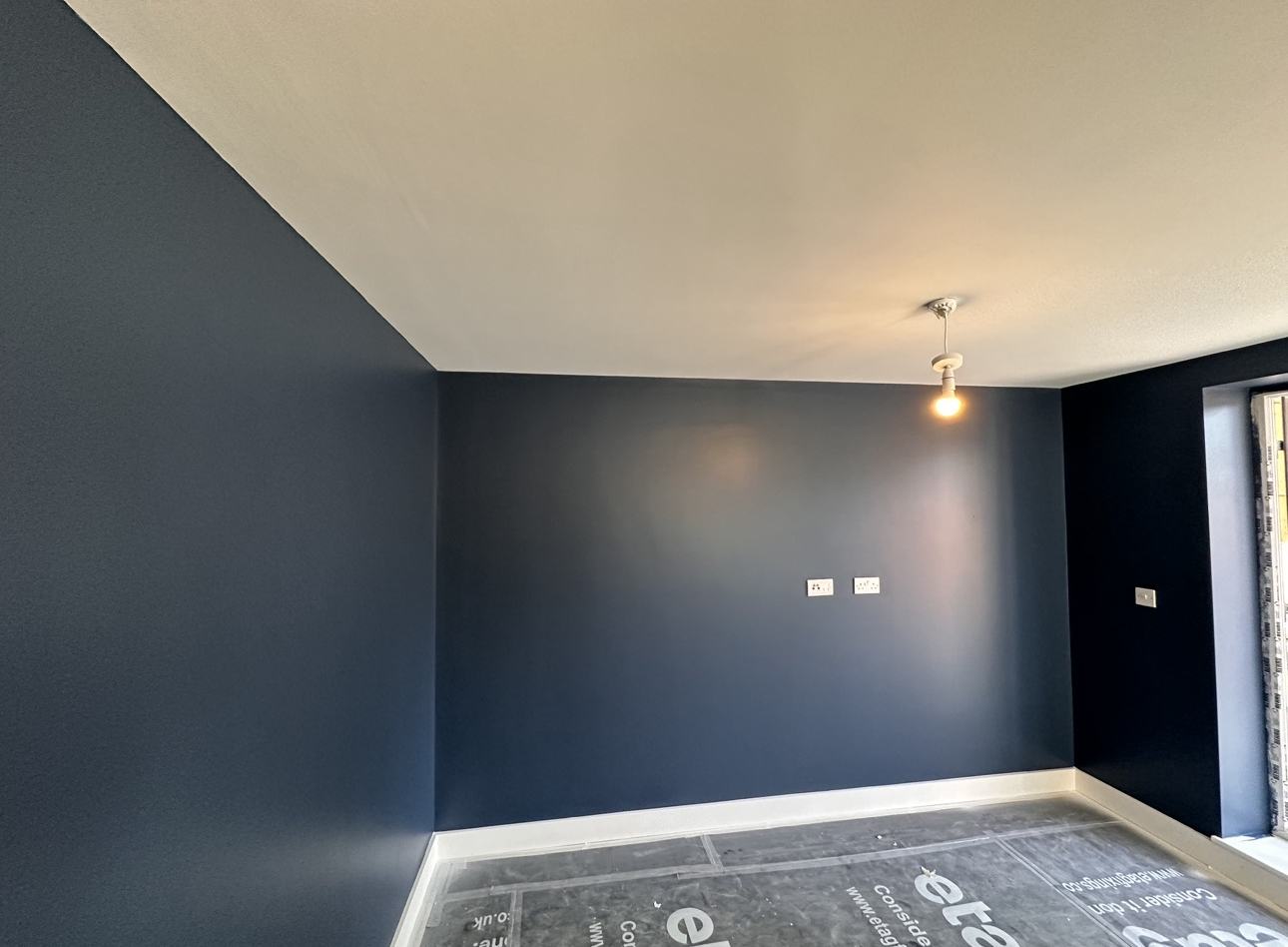 A room with navy walls and a white ceiling