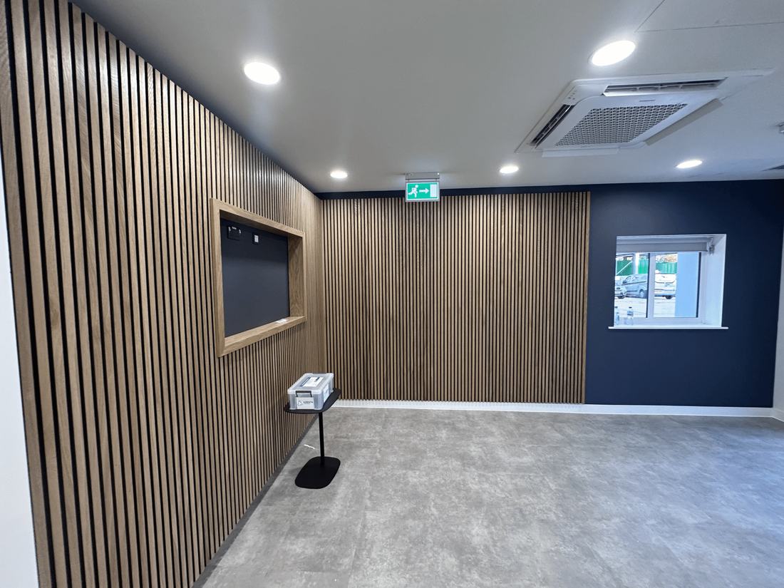 An office fit-out with slatted timber walls and a navy feature wall