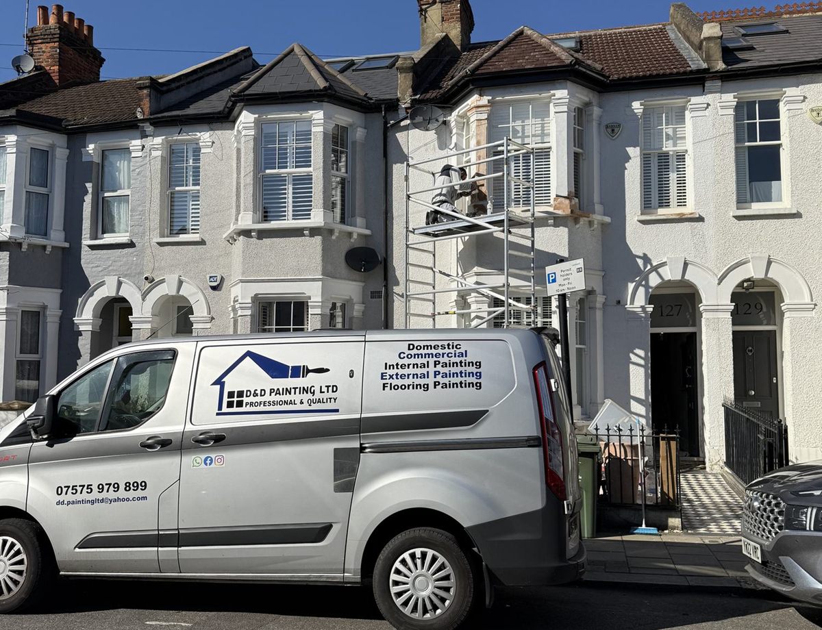 The D&D Painting van parked outside a white Victorian terrace, with a painter on a scaffold tower