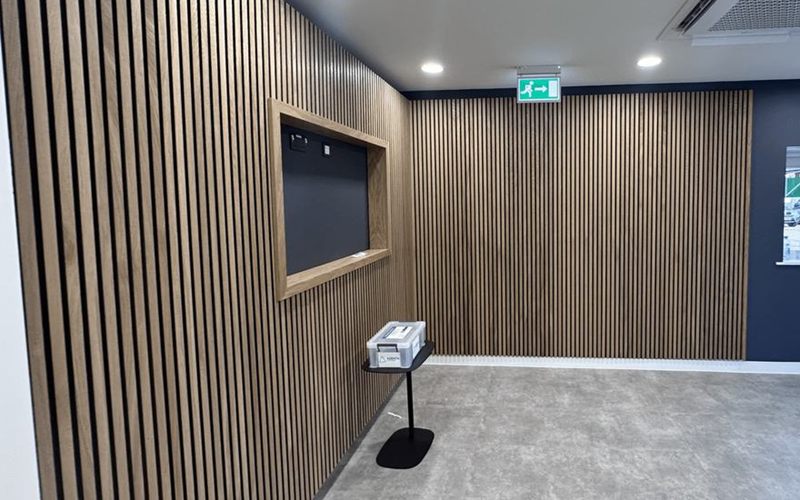 An office fit-out with slatted timber walls and a navy wall