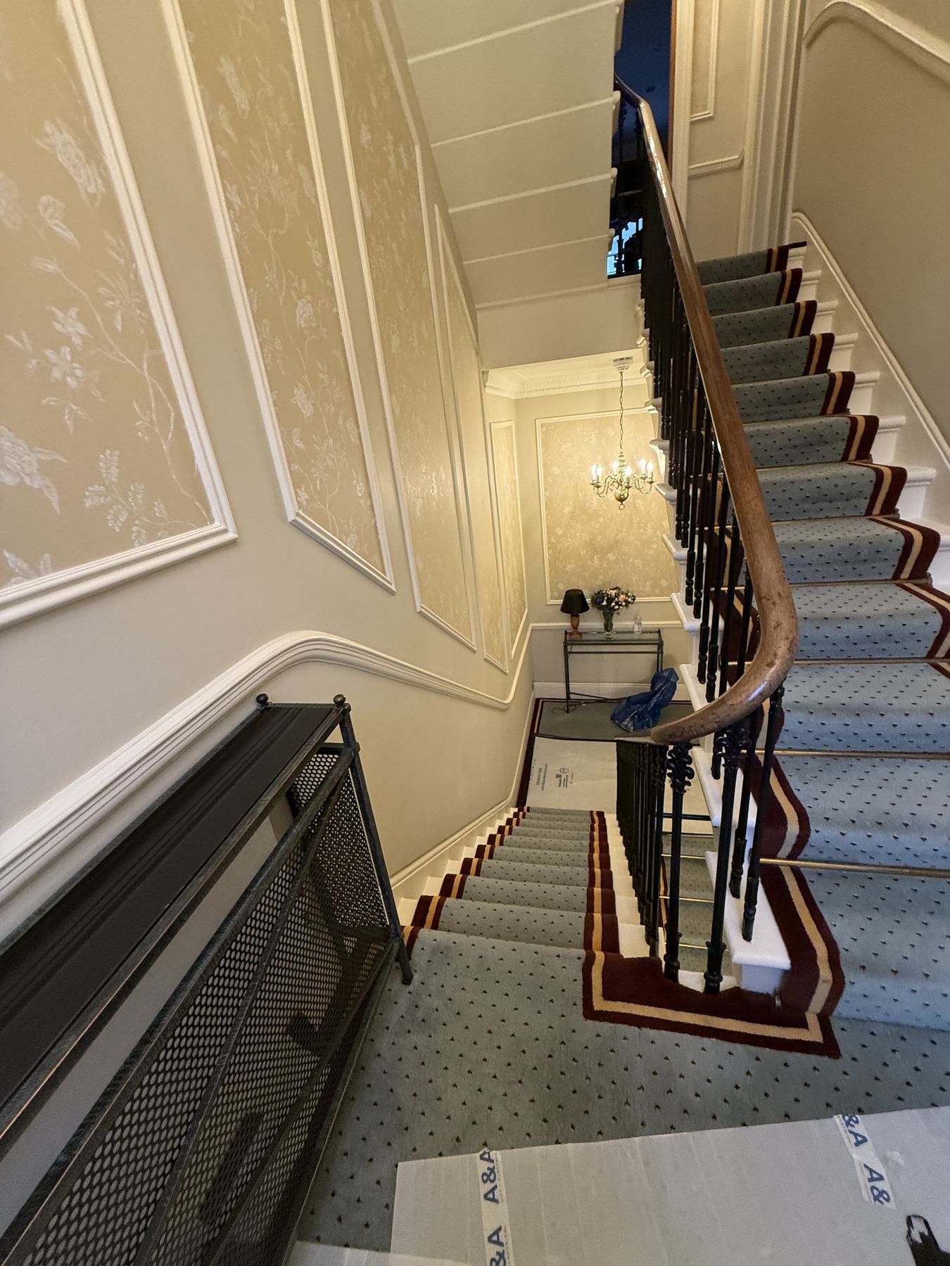 A panelled stair hall with a carpeted staircase