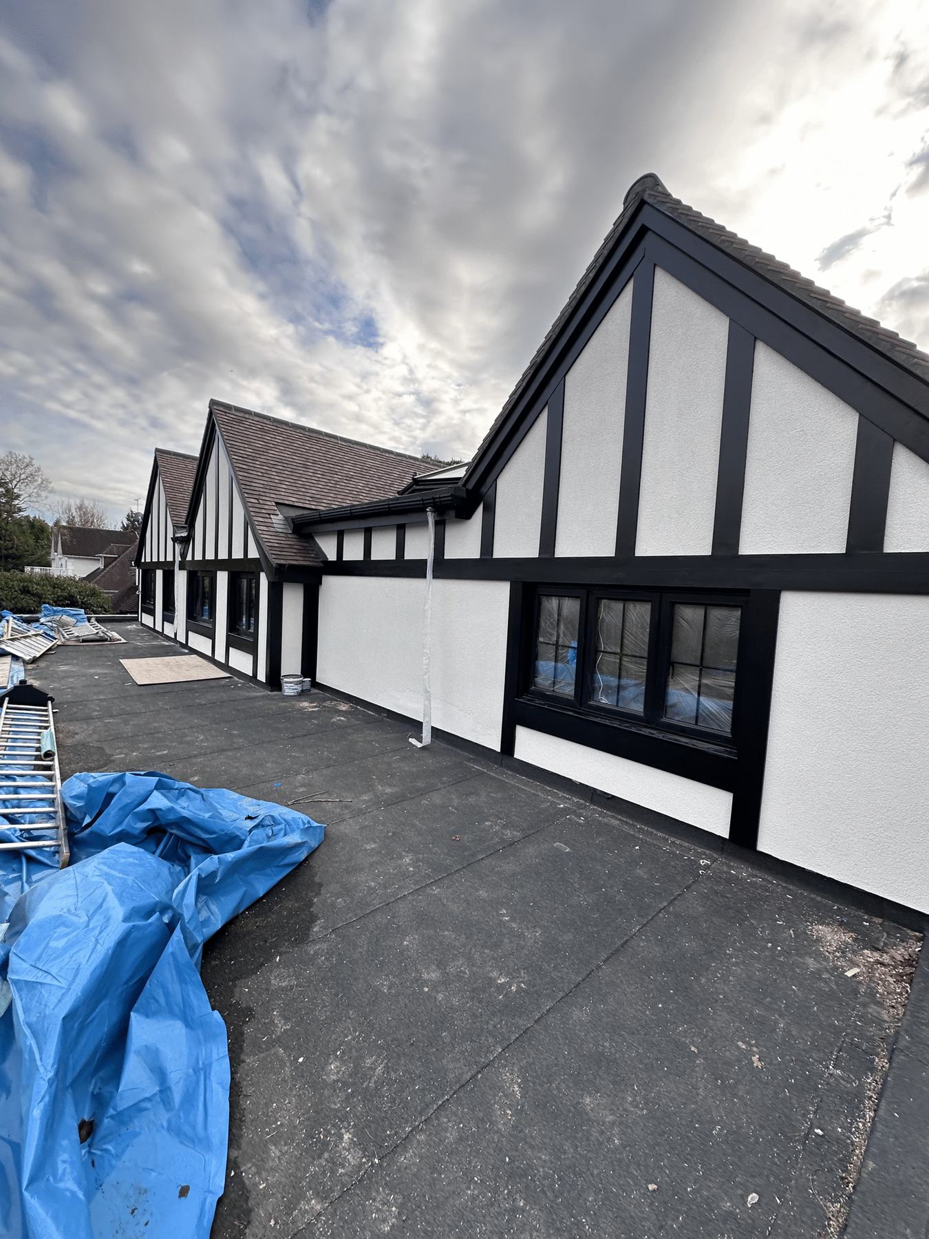 Black and white timber frontage freshly painted, under a bright sky