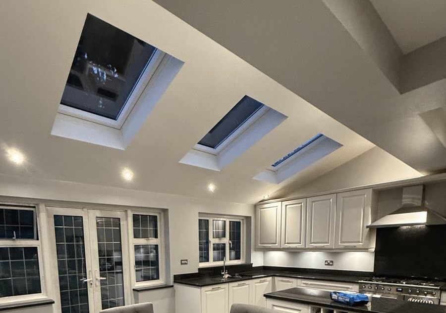 A kitchen extension with three skylights and white cabinets